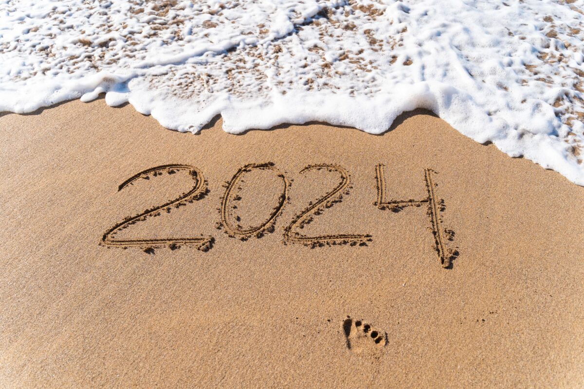 2024 hand written in sand on a beautiful beach UrlaubsExpress